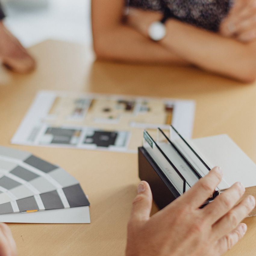 Besprechung von Bau- und Einrichtungskonzepten mit Farbmustern und Materialproben am Tisch