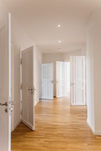 Heller Flur mit Parkettboden und hohen Türen – stilvolles Wohnambiente in einem sanierten Altbau