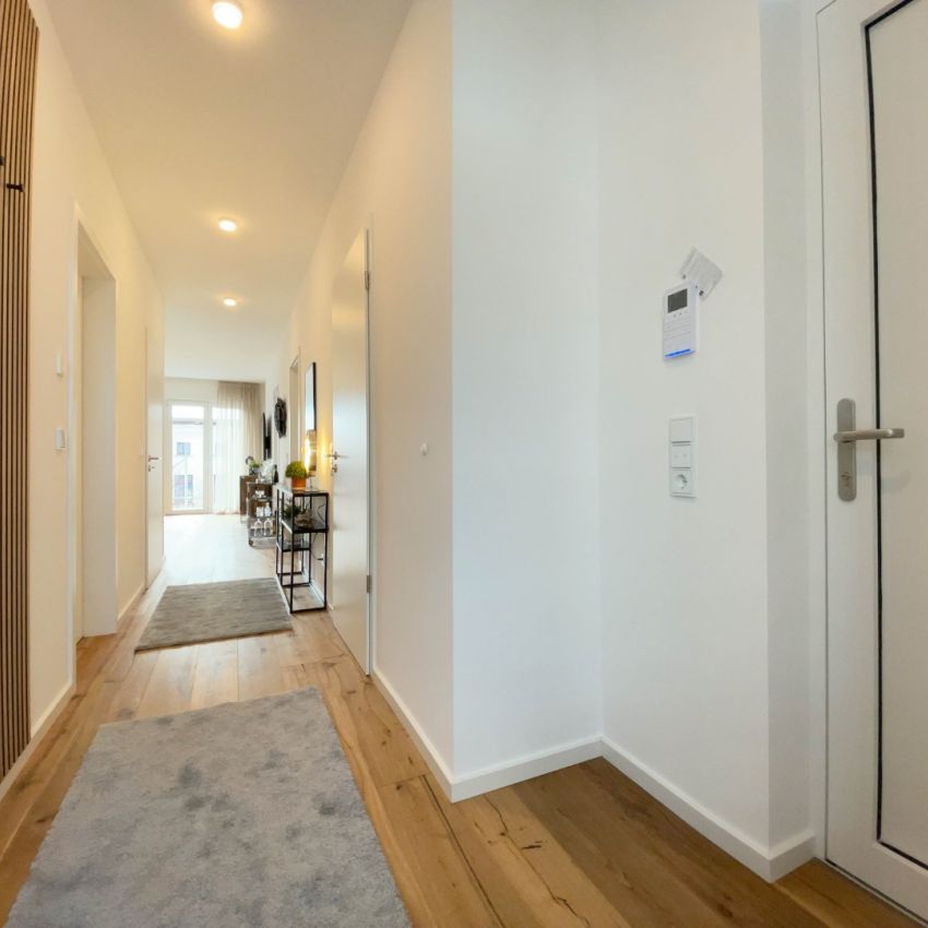 Heller, moderner Flur mit stilvoller Einrichtung und warmem Holzboden