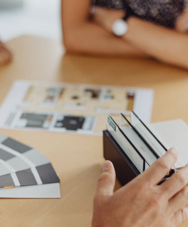Besprechung von Bau- und Einrichtungskonzepten mit Farbmustern und Materialproben am Tisch
