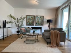 Stilvolles Wohnzimmer mit eleganter Einrichtung, großem Fenster und gemütlicher Atmosphäre