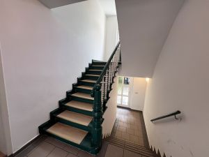 Charmantes Treppenhaus mit historischem Geländer und klassischem Eingangsbereich