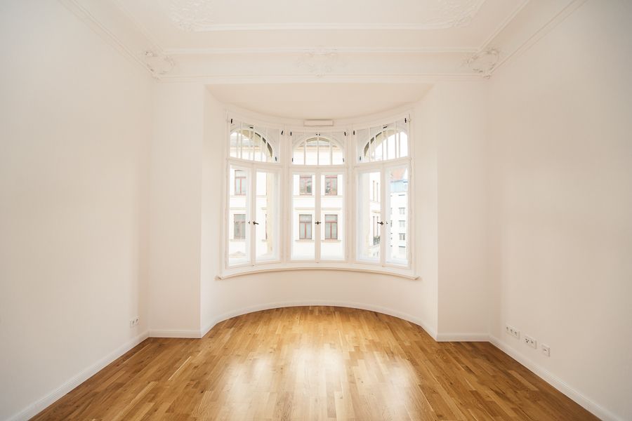 Charmantes Altbauzimmer mit großem Rundbogenfenster, Stuckdecke und edlem Holzboden für stilvolles Wohnen