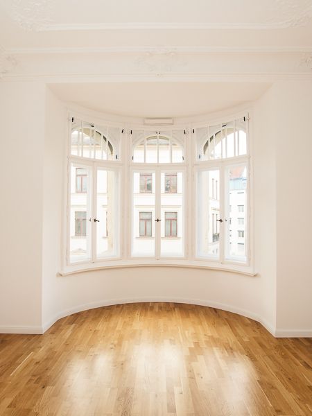 Charmantes Altbauzimmer mit großem Rundbogenfenster, Stuckdecke und edlem Holzboden für stilvolles Wohnen