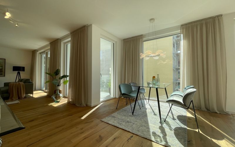 Großzügiges Wohnzimmer mit bodentiefen Fenstern, edlem Holzboden und stilvoller moderner Einrichtung