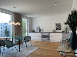 Helle Designküche mit Essbereich, Glas-Esstisch und modernem Wohnambiente in stilvoller Einrichtung